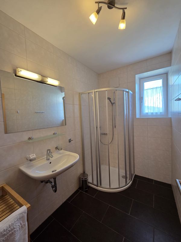 Helles Badezimmer mit Dusche und Waschbecken