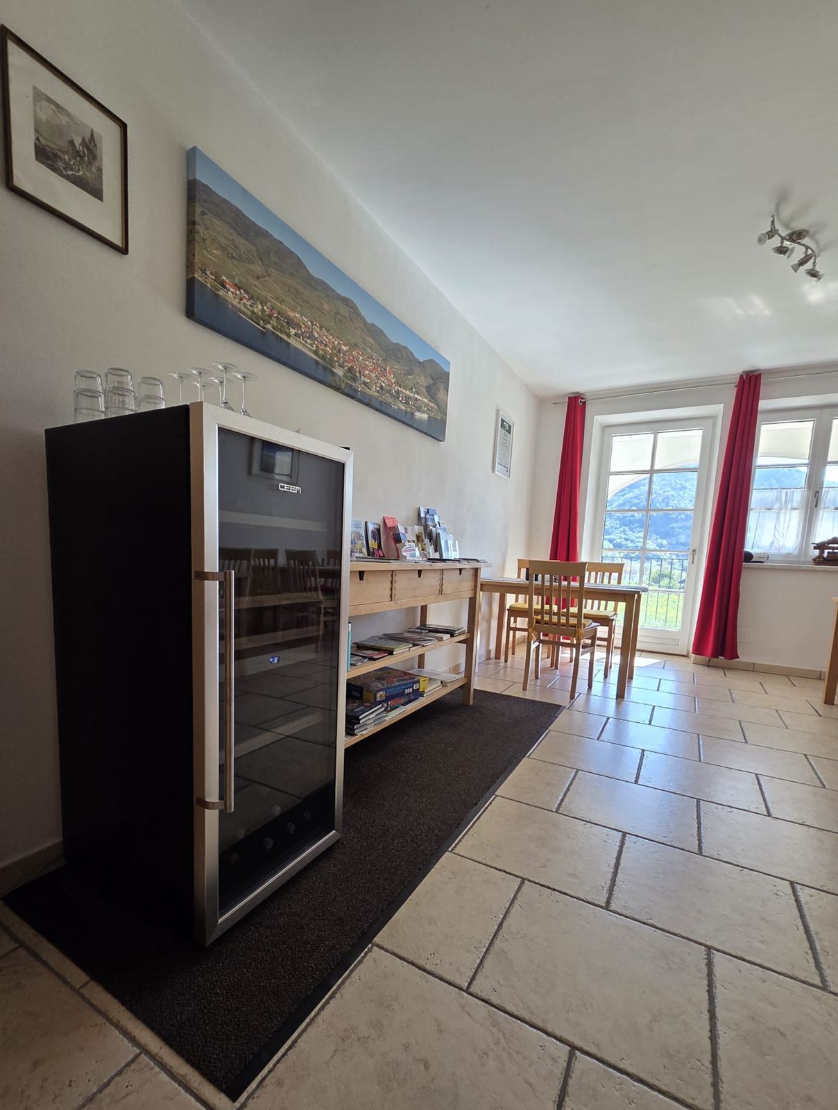 Jausenraum mit Weinkühlschrank, Gläsern und Fenstertür mit Blick ins Grüne