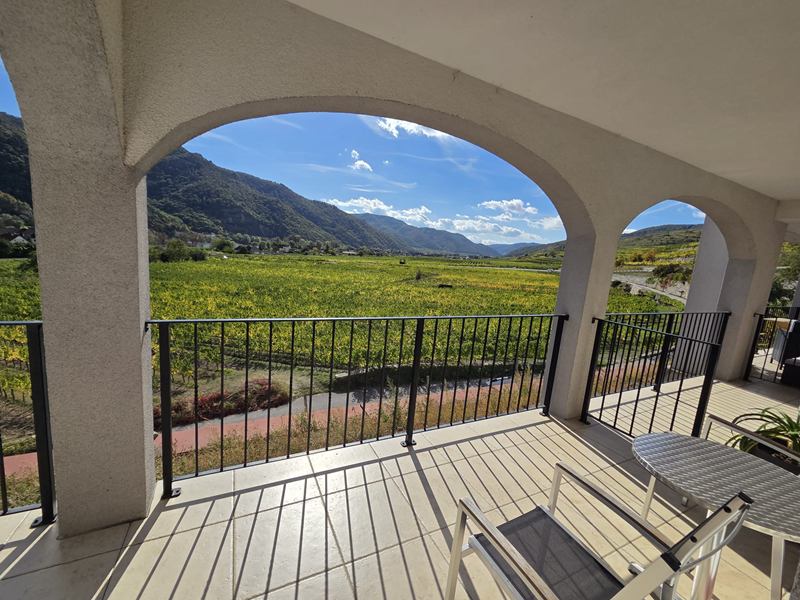 Terrasse unter Rundbögen mit Blick über die Weingärten