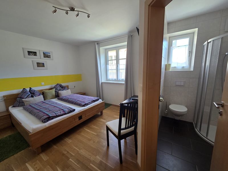 Zimmer Muskateller mit Blick ins Badezimmer mit Dusche und WC